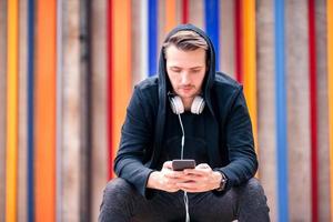 Man is reading text message on mobile phone while walking in the park photo