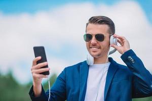 Man is reading text message on mobile phone while walking in the park photo