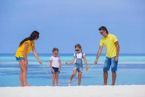 Happy family having fun on white beach photo