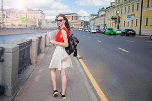 Young happy girl standing on the street in big city smiling photo