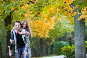 Father and his adorable little daughter outdoors on sunny autumn day photo