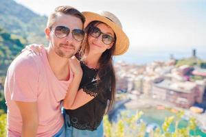 Happy couple with view of the old coastal village, Cinque Terre national park, Liguria, Italy ,Europe photo