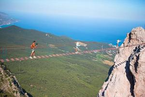 familia cruzando el abismo en el puente de cuerda. fondo del mar negro, crimea, rusia foto