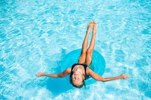 Little adorable girl in outdoor swimming pool photo