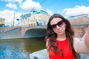 Young caucasian woman making selfie on attractions background outdoors photo