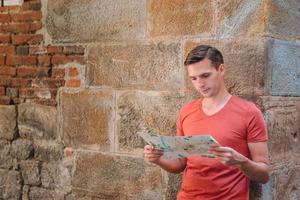 Young man with a city map in european city. photo