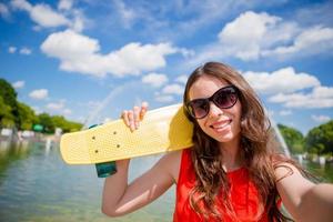 retrato de una joven feliz tomando selfie con patineta al aire libre foto