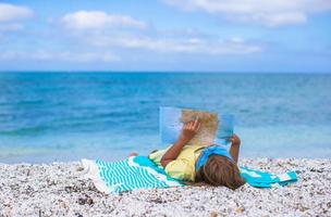 Adorable little girl with big map on tropical beach vacation photo