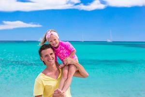 el joven padre y la pequeña hija se divierten durante las vacaciones en la playa tropical foto