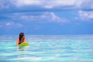 Beautiful surfer woman surfing during summer vacation photo