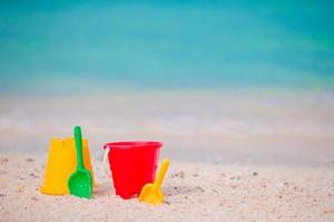 juguetes de playa para niños en arena blanca. cubos y palas para niños en la playa de arena blanca después de los juegos infantiles foto
