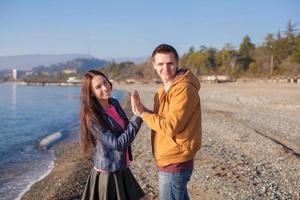 pareja feliz divirtiéndose en la playa en un día soleado de otoño foto