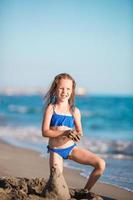 Portrait of adorable little girl at beach during summer vacation photo