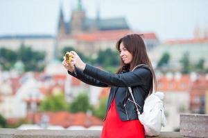 joven mujer caucásica tomando autorretrato en ciudad europea foto
