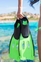 Diving goggles, snorkel and snorkeling fins at woman hands photo