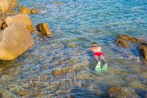 Young man snorkeling in clear tropical turquoise waters photo