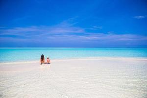 Little girl and young mother during beach vacation photo