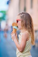 adorable niña comiendo helado al aire libre en verano. foto