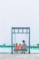 Happy beautiful family of dad and kids on white beach photo