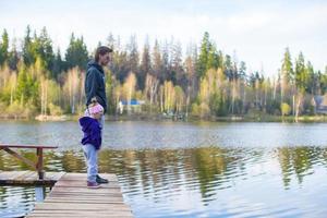 niña y su padre caminando cerca del lago foto