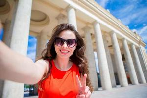 Young caucasian woman making selfie on attractions background outdoors photo