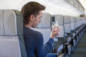 Happy man with small model airplane inside a large aircraft photo