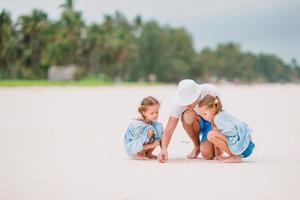 padre e hijos pequeños en la playa foto