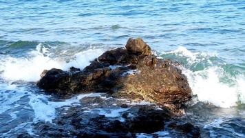 schoonheid rotsachtig strand. kust met vawes en rotsen video