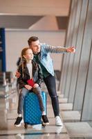 Happy family with luggage and boarding pass at airport waiting for boarding photo