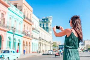 Tourist girl in popular area in Havana, Cuba. Young woman traveler smiling happy. photo