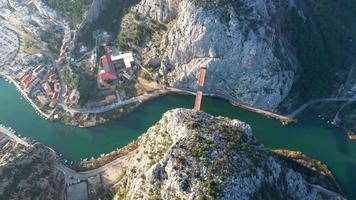 vista aérea drone da cidade de omis na croácia. a localização é onde o rio cetina encontra o mar adriático. bela cidade ao lado das montanhas e do mar. destino de viagens e férias. video