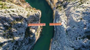 vista aérea de drones del puente inacabado en omis, croacia sobre el río cetina. puente que se está construyendo entre el cañón. construccion industrial y compleja en la zona de dalmacia. video