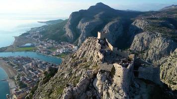 Aerial drone panorama view of Omis town in Croatia. Location is where the Cetina River meets the Adriatic Sea.  Beautiful city next to the mountains and the sea. Travel and holidays destination. video