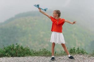 Beautiful happy little girl in mountains in the background of fog photo