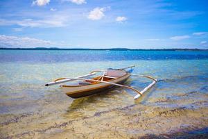 pequeño barco de pesca en la playa tropical blanca foto