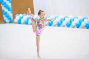 hermosa niña gimnasta activa con su actuación en la alfombra foto