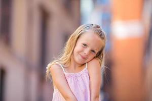 Adorable happy little girl outdoors in italian city. Portrait of caucasian kid enjoy summer vacation in Rome photo