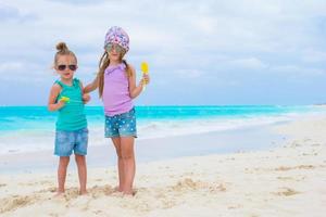 Little adorable girls on white tropical beach photo