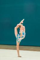 Beautiful little active gymnast girl with her performance on the carpet photo