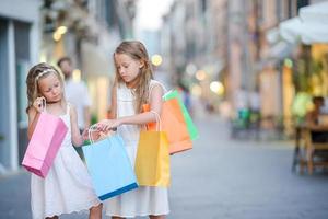 Pretty smiling little girls with shopping bags photo