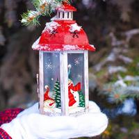 Beautiful red decorative Christmas lantern on warm mittens photo