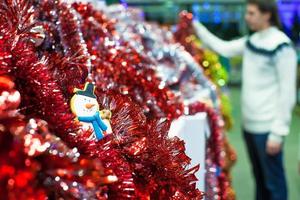 Young man choosing decorations on the Christmas tree photo