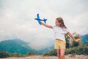 Beautiful happy little girl in mountains in the background of fog photo