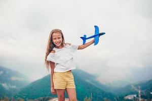 Beautiful happy little girl in mountains in the background of fog photo