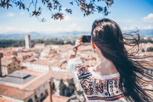 joven mujer caucásica haciendo fotos por teléfono móvil desde el lugar de observación