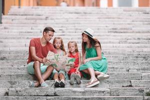 Happy family of four in Rome with map photo