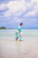 Adorable little girls and young father during beach vacation photo