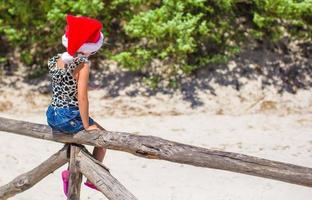 linda niña hermosa con sombrero de santa durante las vacaciones foto