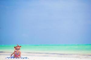 Adorable little girl at beach during summer vacation photo