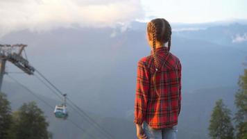 bellissimo contento poco ragazza nel montagne nel il sfondo di nebbia video